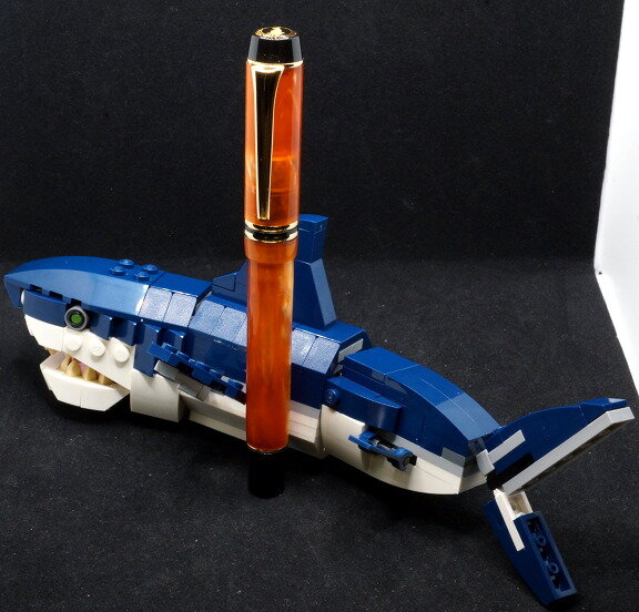 Swirly orange Kaigelu 316 pen leaning against Lego shark